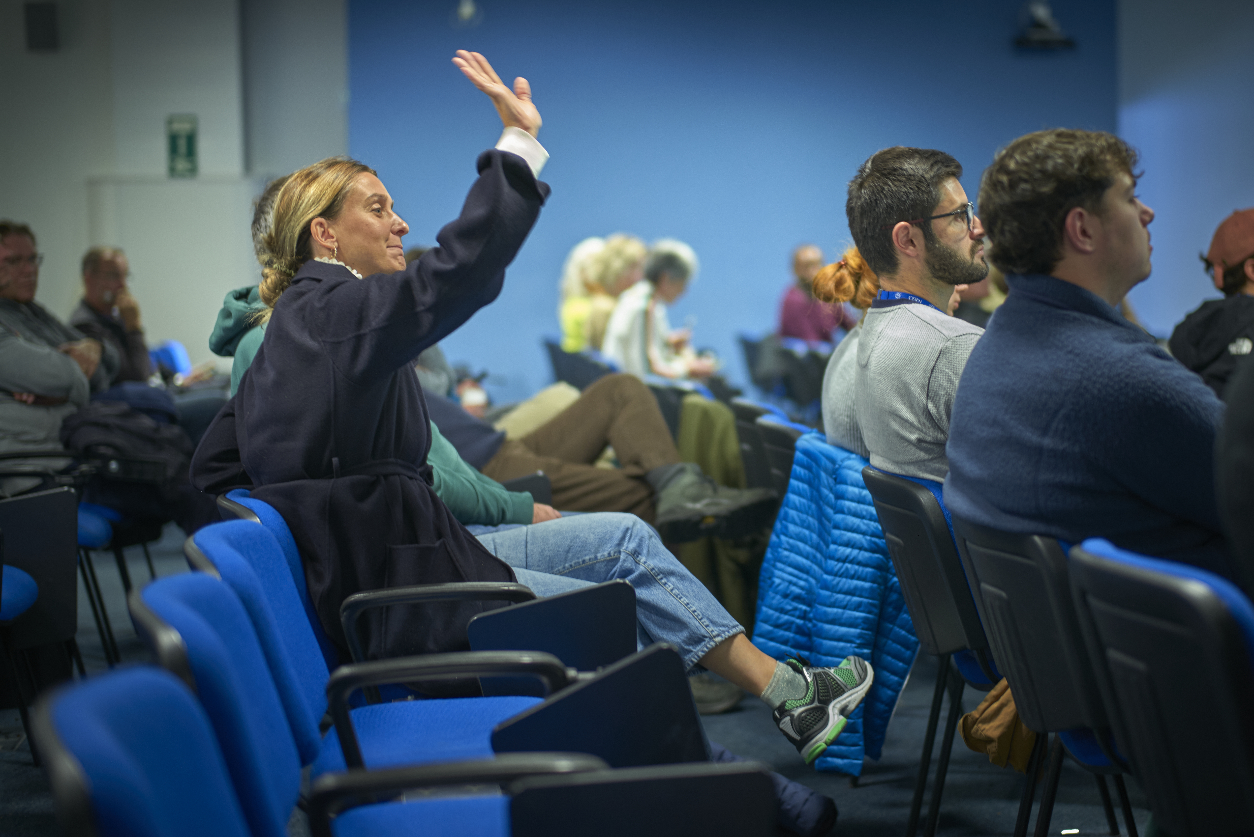 A volunteer raises her hand to give feedback.