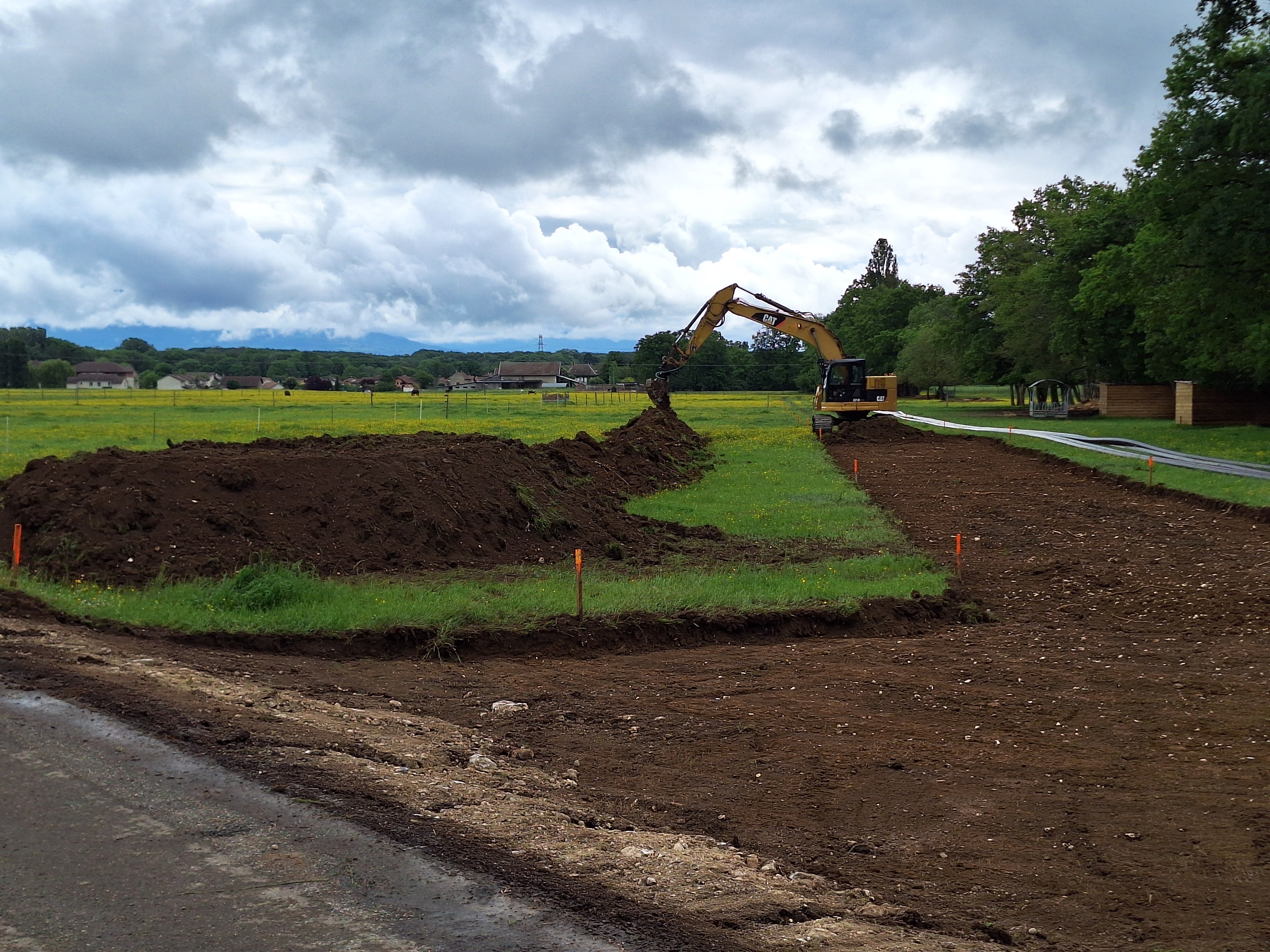 A digger seperates fertile topsoil from the mid-layer according to swiss regulations.